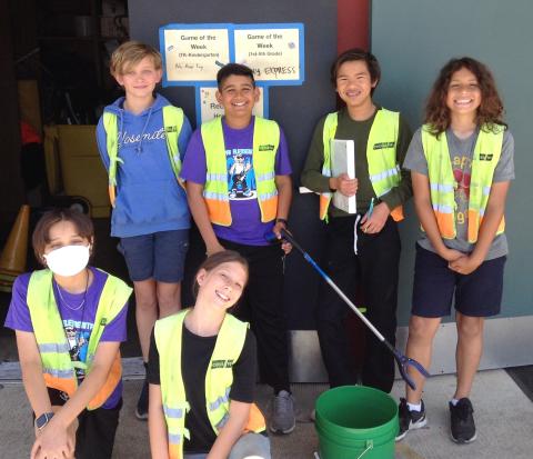 7 5th grade students in yellow safety vests represent the school's trash patrol